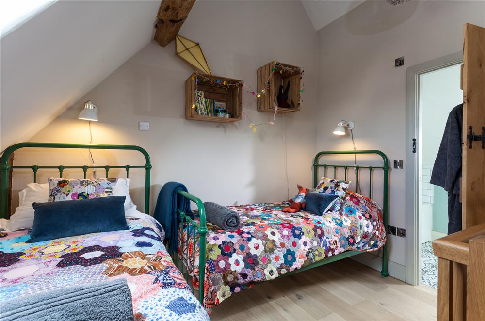 Bedroom two with twin 3’ single metal framed beds and en-suite bathroom at The Byre, Bridgnorth