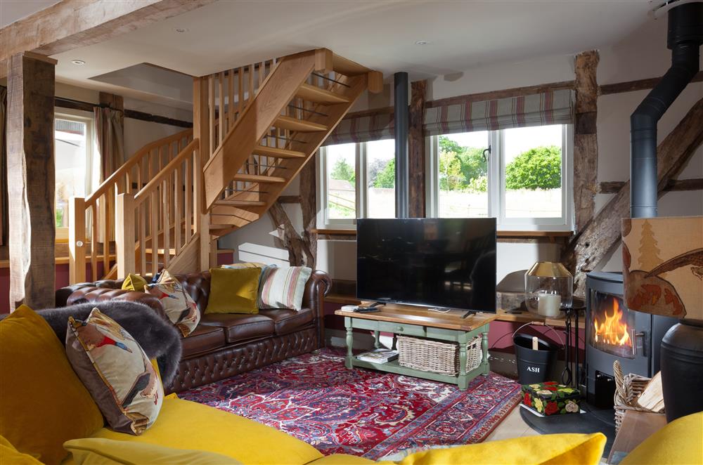 Sitting room with sumptuous seating and stairs leading to bedroom one at The Byre, Bridgnorth