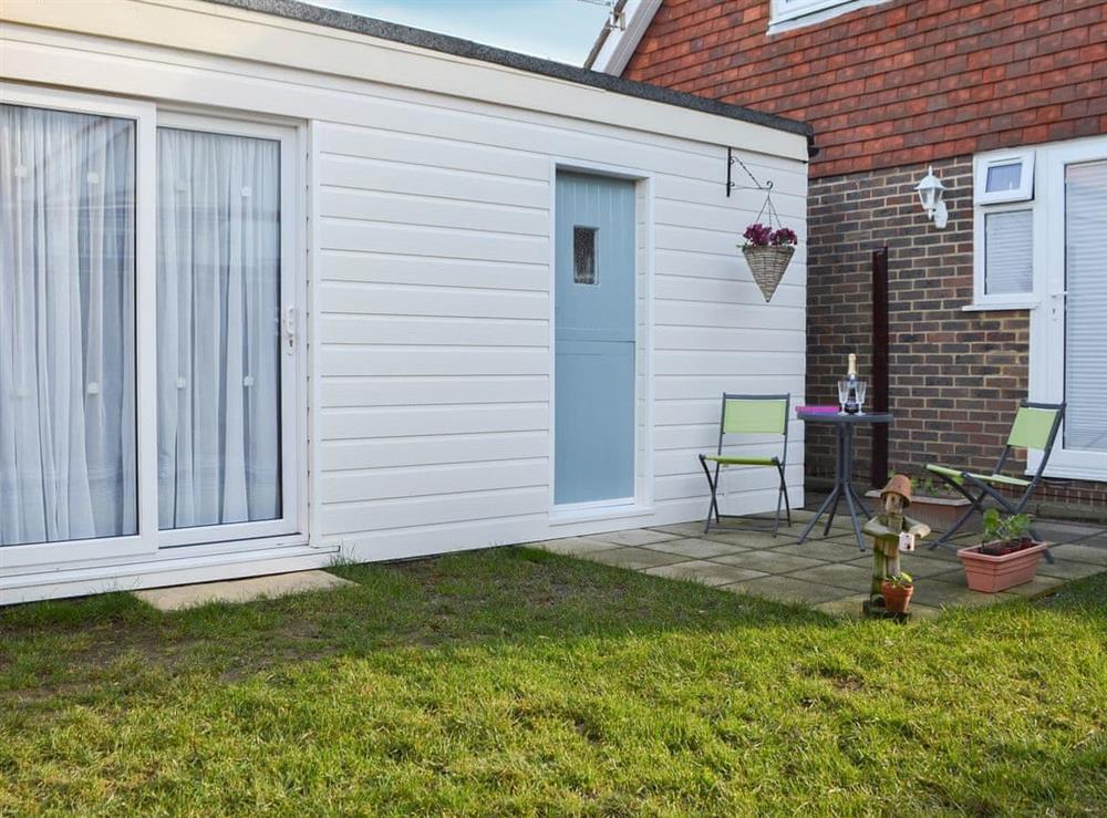 Garden area with seating at The Cabin in Pevensey Bay, near Eastbourne, East Sussex