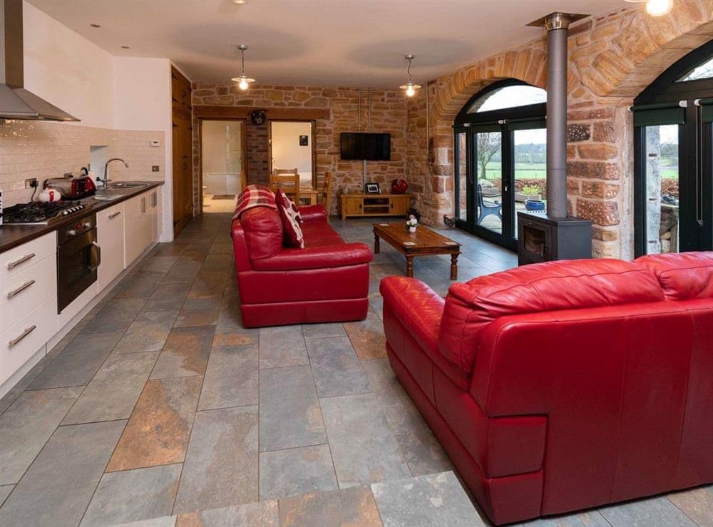 Cosy living area with wood-burning stove and large arched windows at The Cart House in Mauchline, near Ayr, Ayrshire