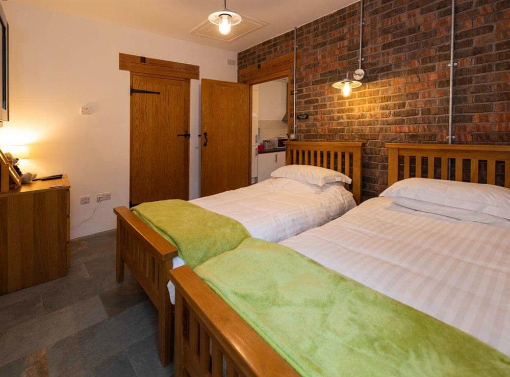 The twin bedroom has a stone feature wall at The Cart House in Mauchline, near Ayr, Ayrshire