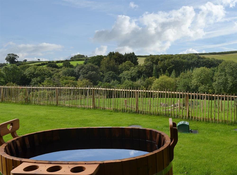 Admire the breathtaking view from the wood-fired hot tub at The Cart Linhay in Meshaw, near South Molton, Devon