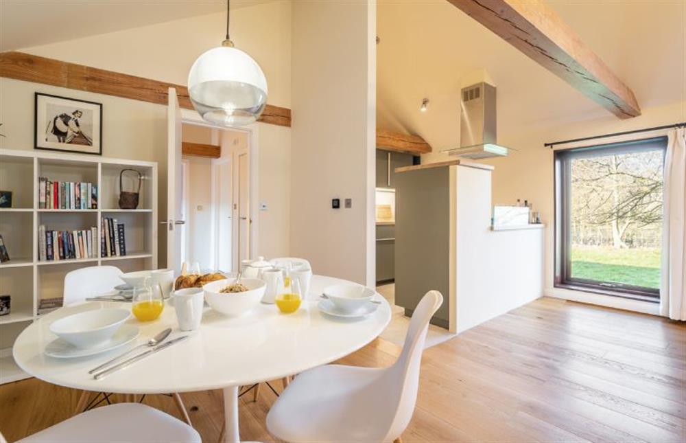 Dining area and kitchen with large window overlooking the garden at The Cart Lodge, Thornham Magna