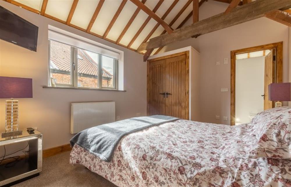 Ground floor: Bedroom with king-size bed and wall-mounted Smart television  at The Cart Shed, Paston near North Walsham
