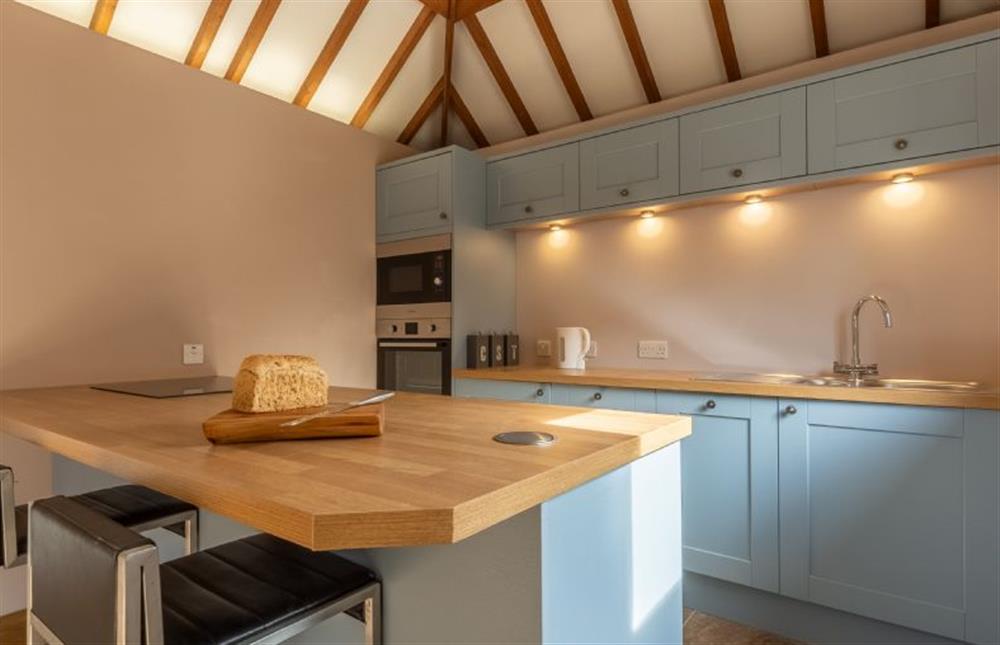 Ground floor: Kitchen with sit up island with seating for two at The Cart Shed, Paston near North Walsham