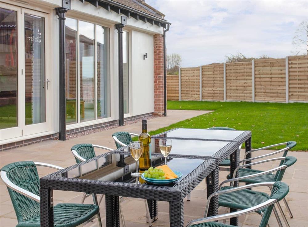 Paved patio area with outdoor furniture within garden at The Cartshed in Slindon, near Eccleshall, Staffordshire