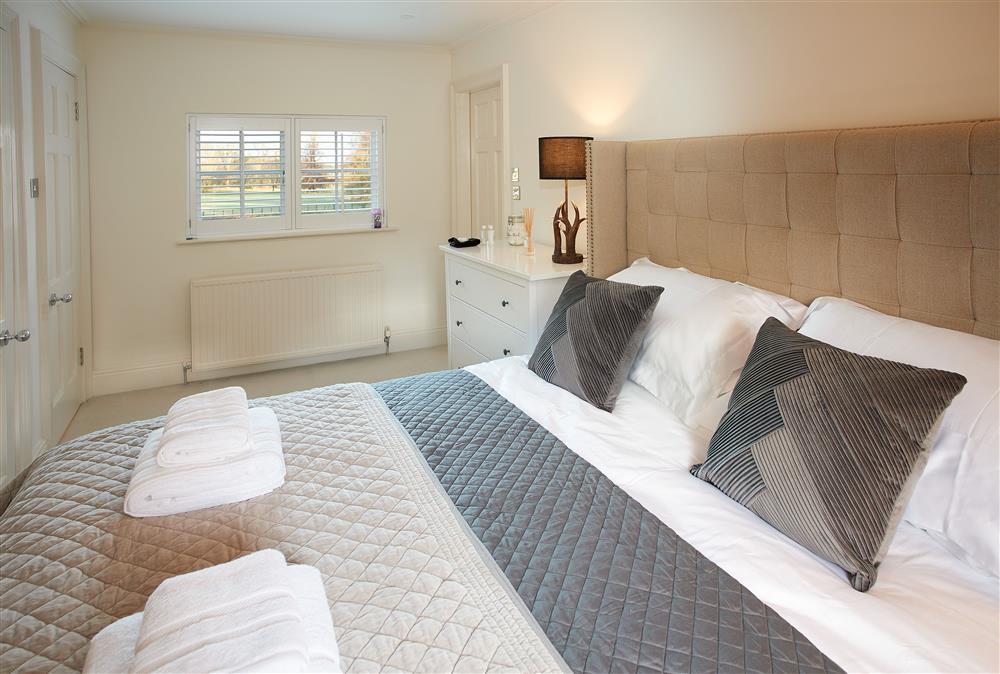 Bedroom one with 6’ super- king size bed and en-suite bathroom at The Chapel House, Arley
