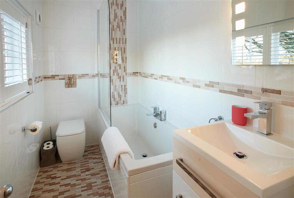 En-suite bathroom with bath and overhead shower at The Chapel House, Arley