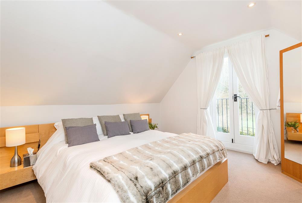 Bedroom one with 5’ king-size bed and Juliet balcony at The Chestnuts, Shilton