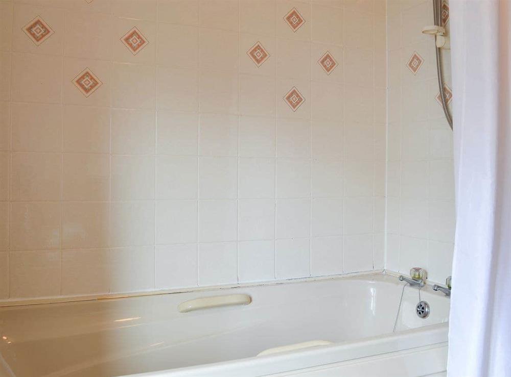 Tiled bathroom with shower over bath at The Cider Mill Cottage in Orleton, near Ludlow, Shropshire