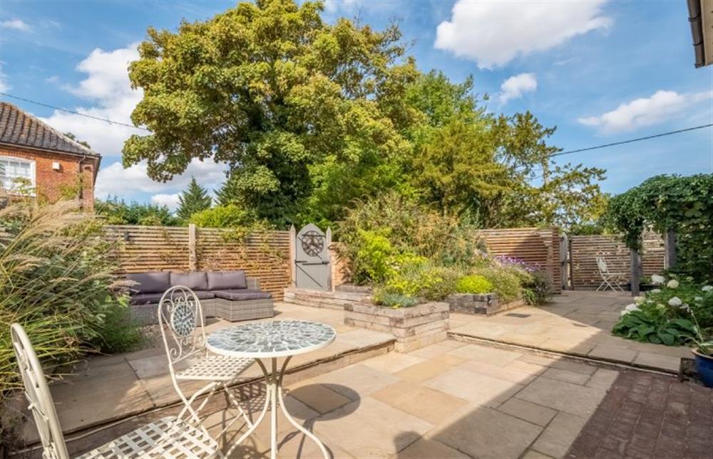 The spacious patio garden, with comfortable seating perfect for long summer evenings at The Clockhouse, North Lopham