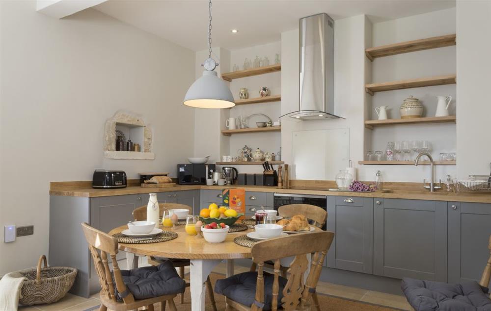 Kitchen and dining area with folding table extending to seat eight guests at The Coach House and Stables at The Lammas, Minchinhampton