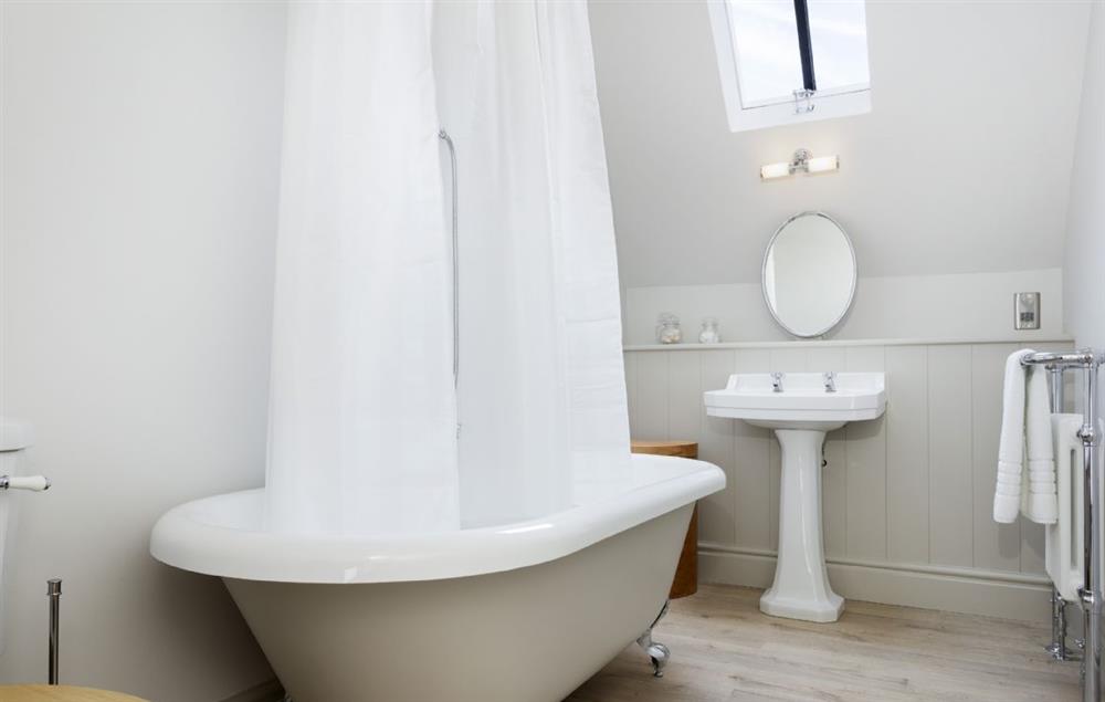 En-suite bathroom with roll-top bath and shower over (photo 2) at The Coach House at The Lammas, Minchinhampton