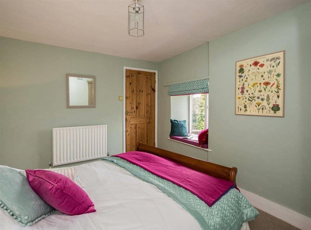 Pretty bedroom with large bed at The Coach House in Fremington, near Richmond, North Yorkshire