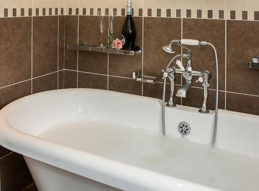 Wonderful romantic bathroom with roll top bath and telephone style shower attachment at The Coach House in Fremington, near Richmond, North Yorkshire