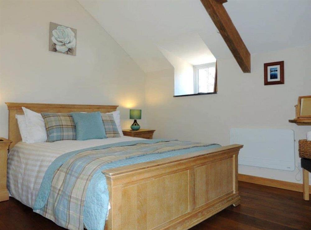 Impressive double bedroom with dual aspect wood burner at The Coach House Loft in Llangrannog, Dyfed