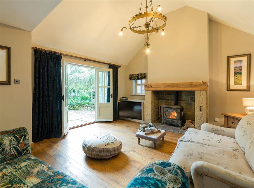 Comfy Living room with wood burner and French doors leading to garden at The Coach House in Riding Mill, near Corbridge, Northumberland