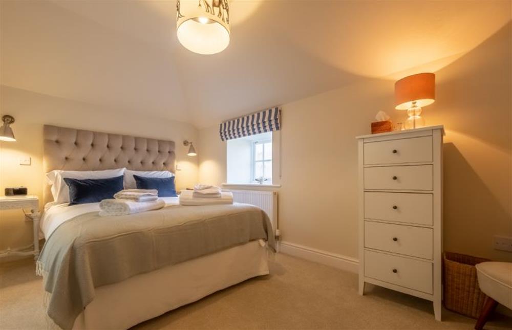 The master bedroom has a luxurious king-size bed at The Coach House, Ringstead near Hunstanton