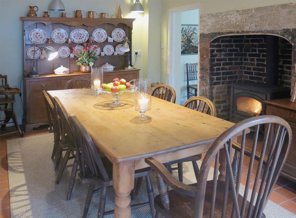A grand farmhouse kitchen style table and a woodburning stove complement the traditional cottage furnishings at The Coach House in Tenbury Wells, Worcestershire