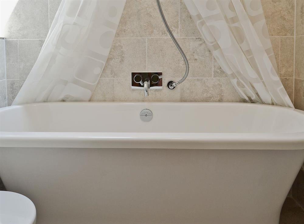 The bathroom has a shower over the roll top bath at The Coach House in Tenbury Wells, Worcestershire