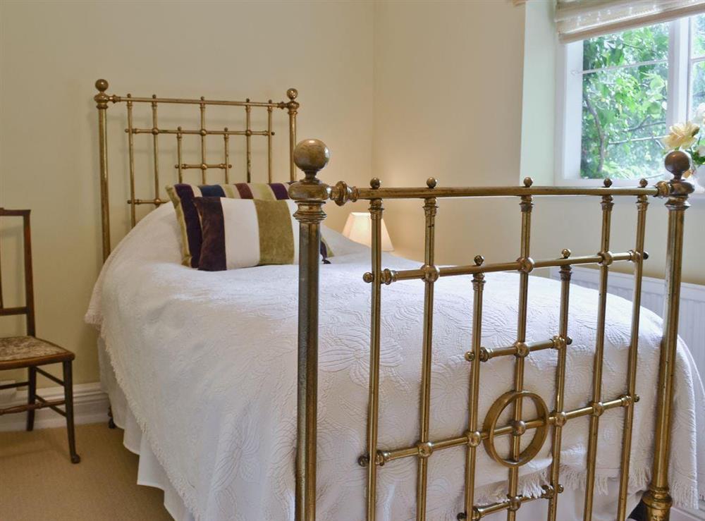 The single bedroom has a traditional brass bedstead at The Coach House in Tenbury Wells, Worcestershire