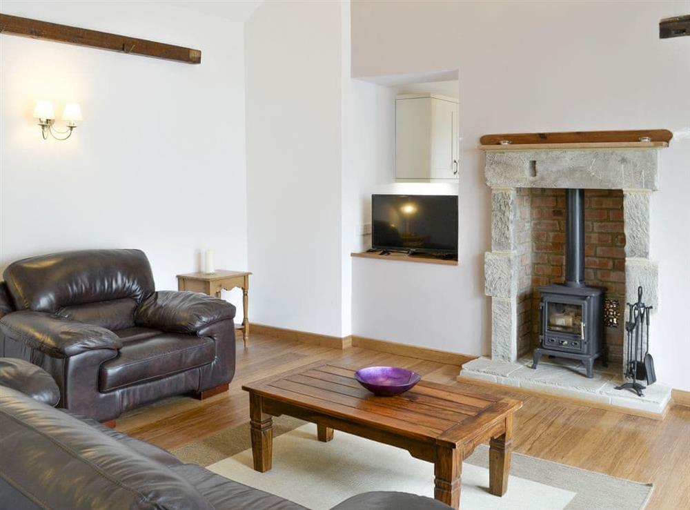 Welcoming living area with wood burner at The Coach House in Whittingham near Alnwick, Northumberland, England