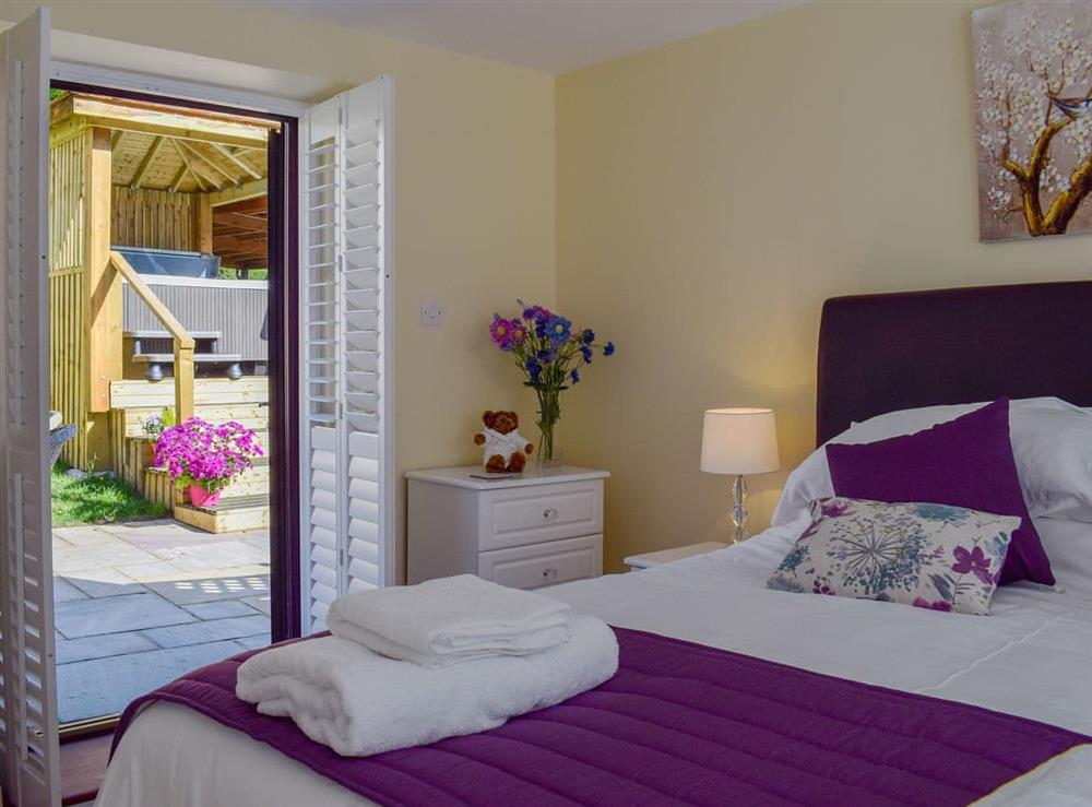 Comfortable double bedroom with patio doors at The Coach House in Wootton, near Ryde, Isle of Wight