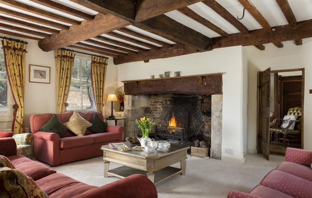 The spacious drawing room with exposed beams and open fire at The Coppice, Ashton under Hill