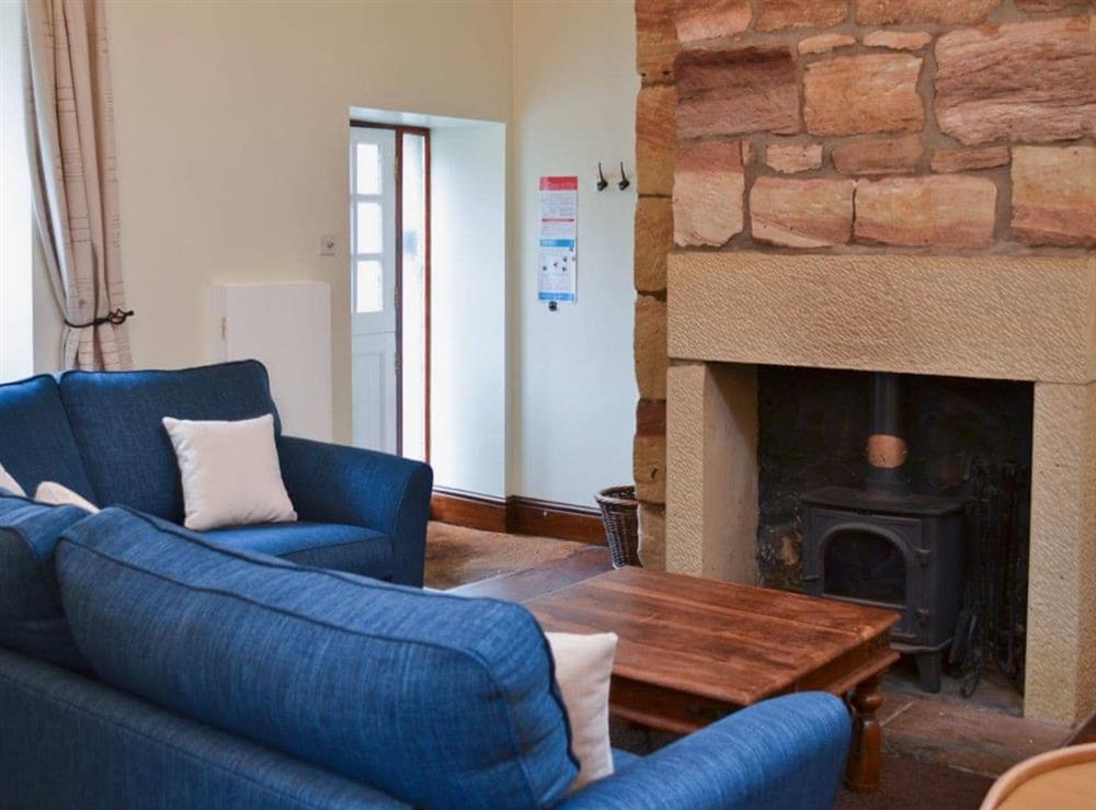 Living room area with a cosy woodburner at The Coracle in Seahouses, Northumberland