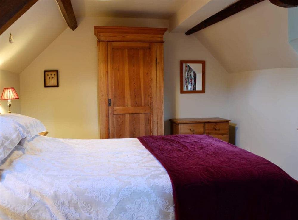 Quirky double bedroom with slopoing ceilings at The Cot in Bussage, near Cirencester, Gloucestershire