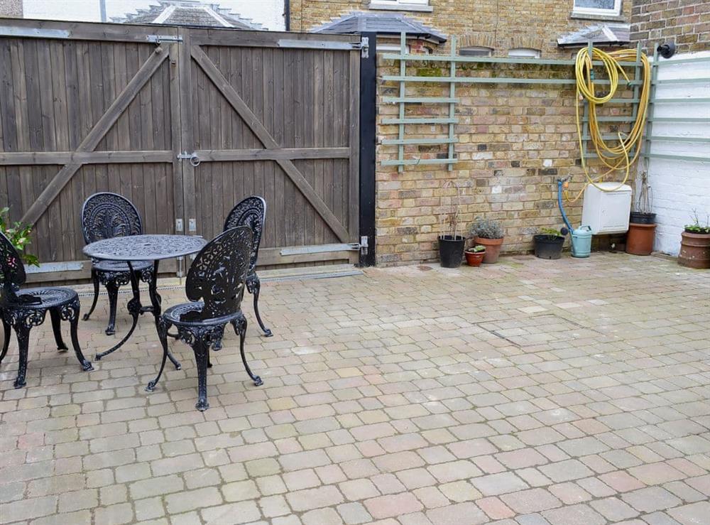 Small courtyard with sitting-out area, garden furnitureand private parking for 1 car at The Cottage in Broadstairs, Kent, England