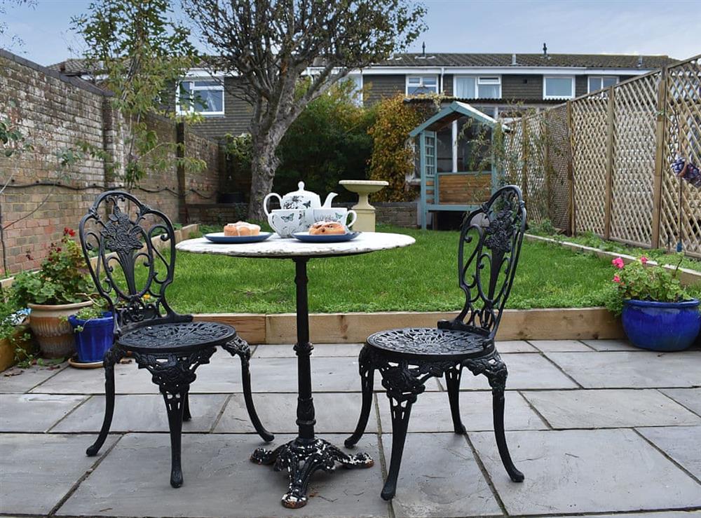 Paved patio area with furniture overlooking the garden at The Cottage By The Sea Annexe, 