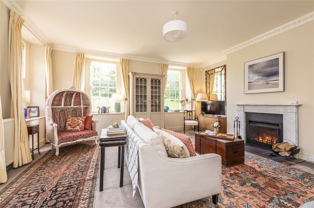 The spacious sitting room with open fire and elegant furnishings at The Courtyard House, Dorchester