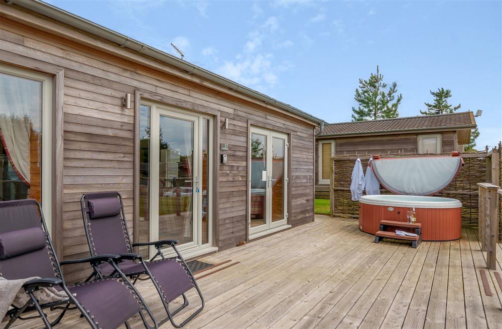 The sun deck, complete with a hot tub, garden furniture and sun loungers at The Cow Shed, Sherborne