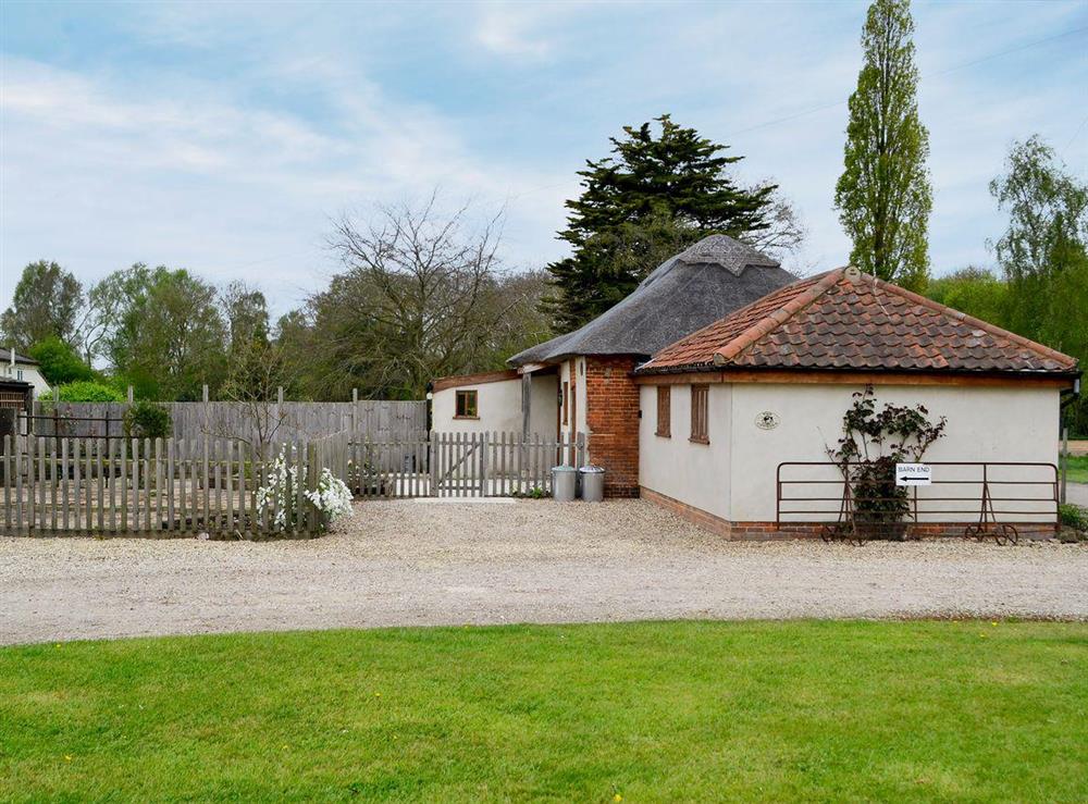 Spacious enclosed garden with sitting-out area and garden furniture at The Cowshed in Blofield, near Norwich, Norfolk