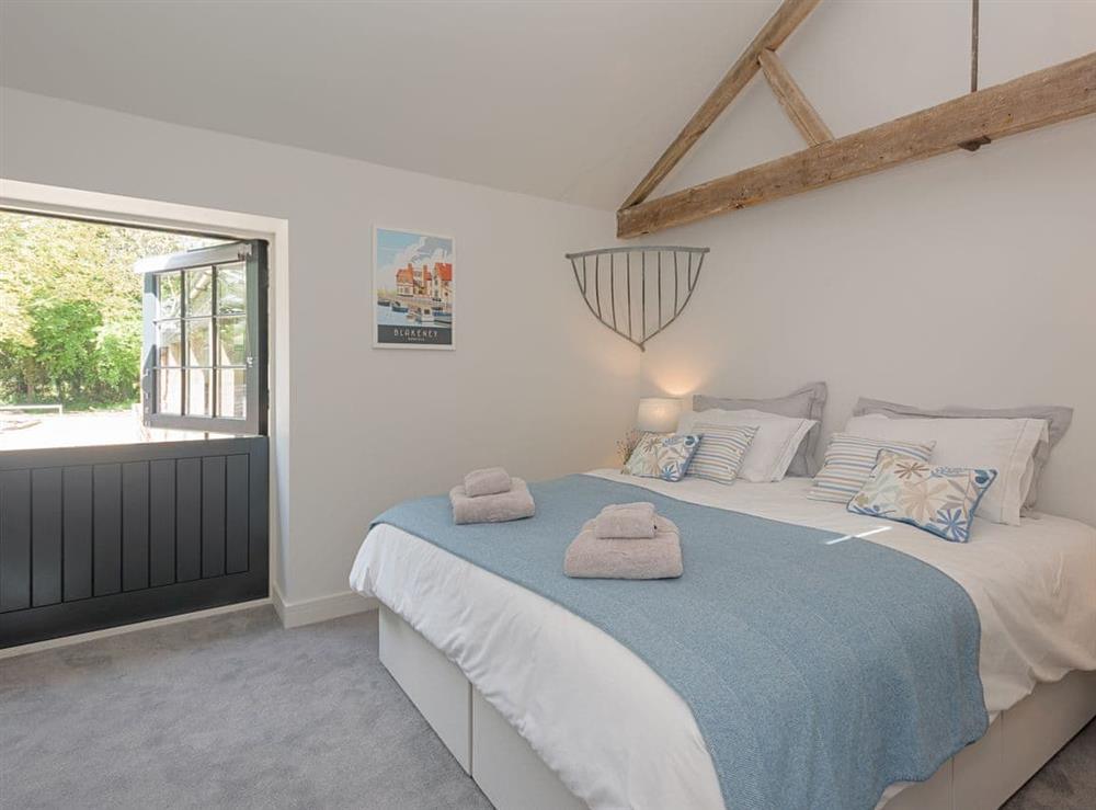 Comfortable second en-suite double bedroom with door to enclosed patio at The Cowshed in Reepham, Norfolk