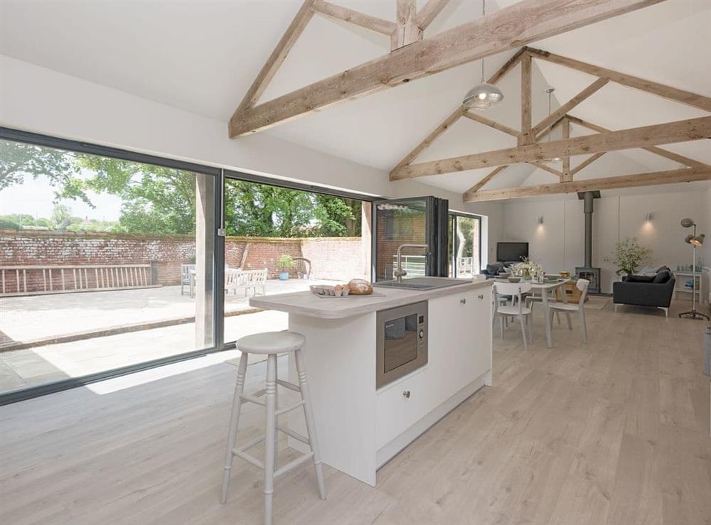 Modern open-plan living space with exposed wooden trusses at The Cowshed in Reepham, Norfolk