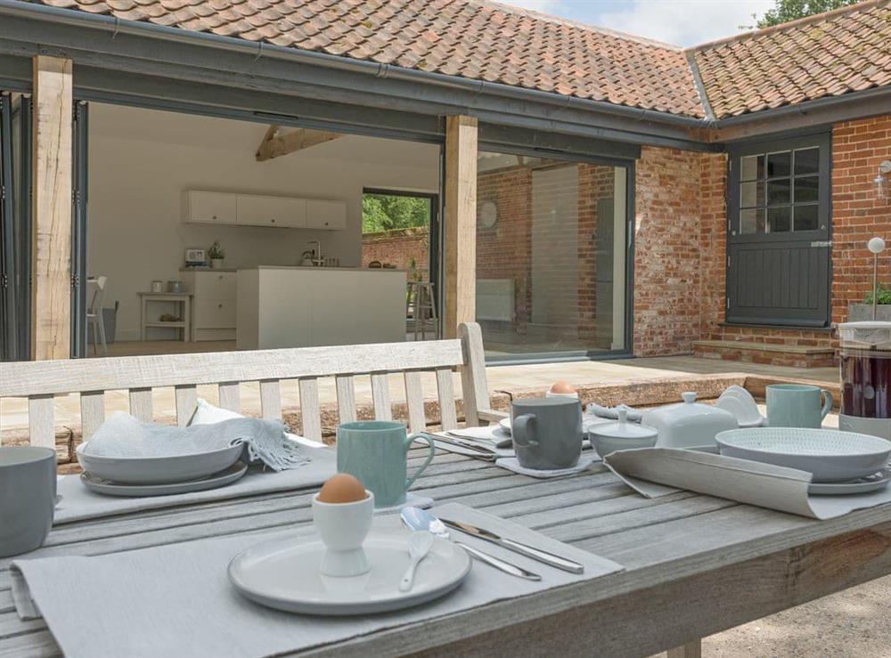 Outdoor dining furniture on patio at The Cowshed in Reepham, Norfolk