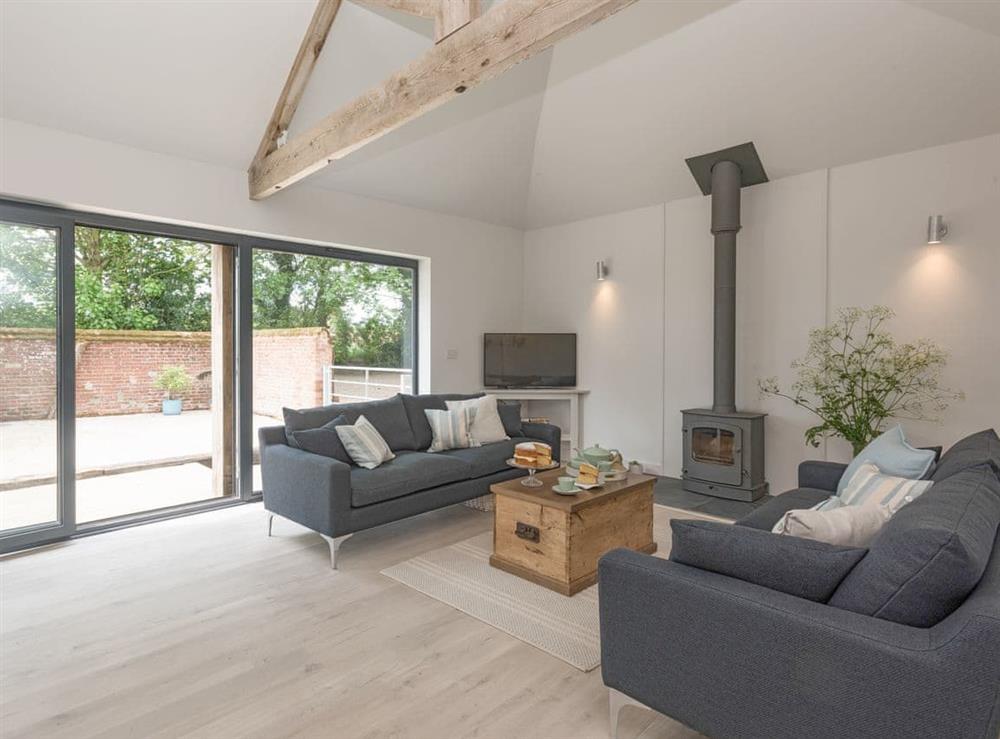 Welcoming living area with wood burner at The Cowshed in Reepham, Norfolk