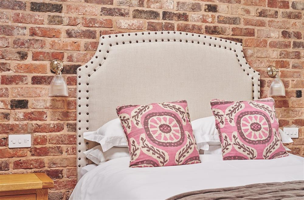 The king-size bed against the exposed brick wall