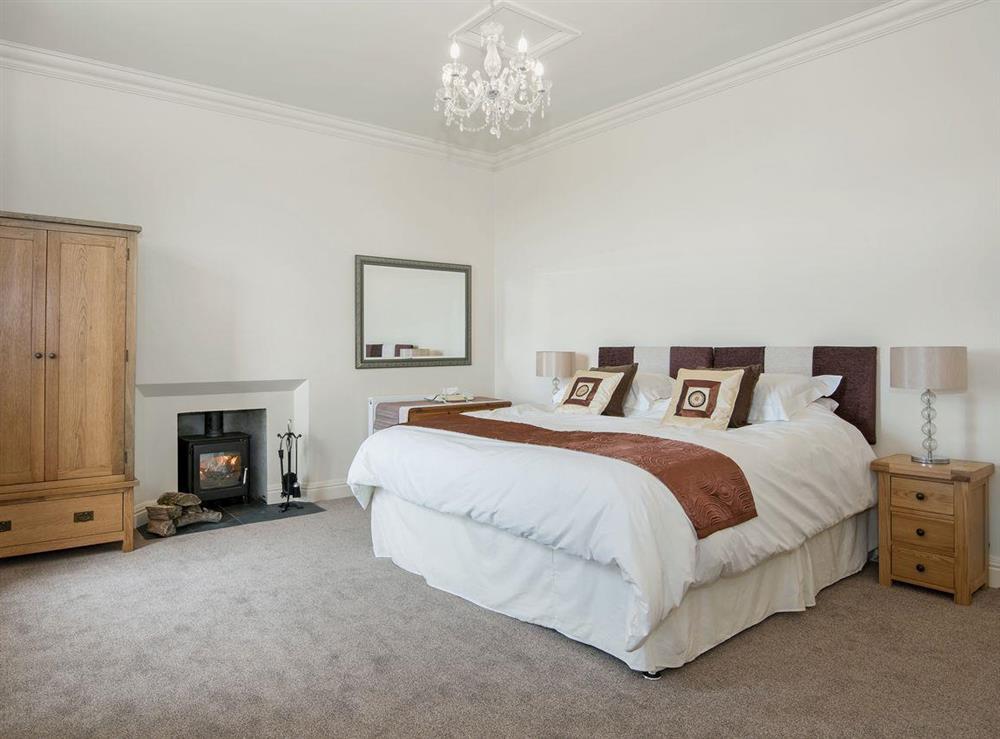 Spacious double bedroom with cosy woodburner and TV at The Duchy in Kirkcudbright, Kirkcudbrightshire