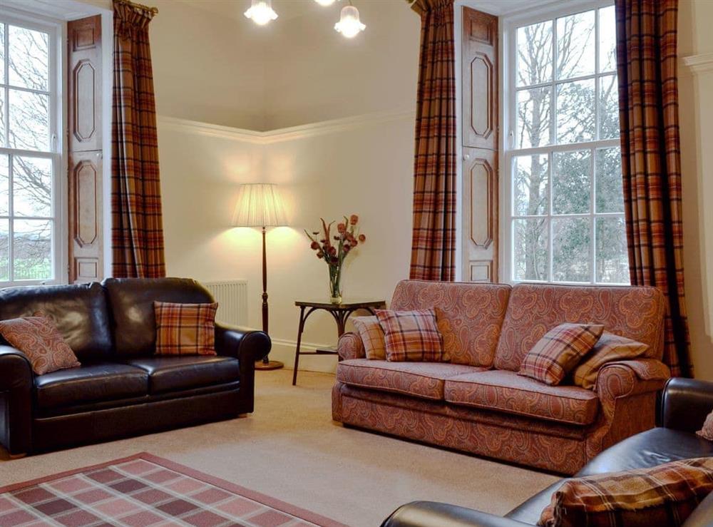 Characterful living room with high ceiling and large windows at The Factor’s House in Kilmartin Glen, near Lochgilphead, Argyll