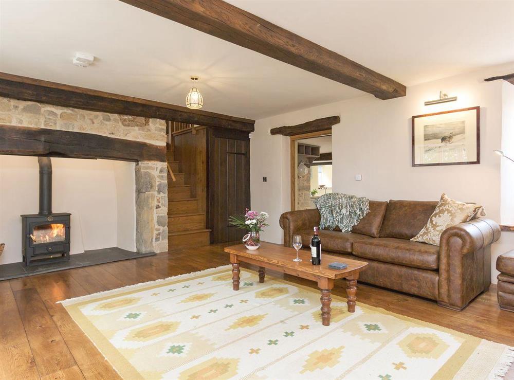 Cosy, beamed living room with wood burner at The Farmhouse at Higher Westwater Farm in Axminster, Devon
