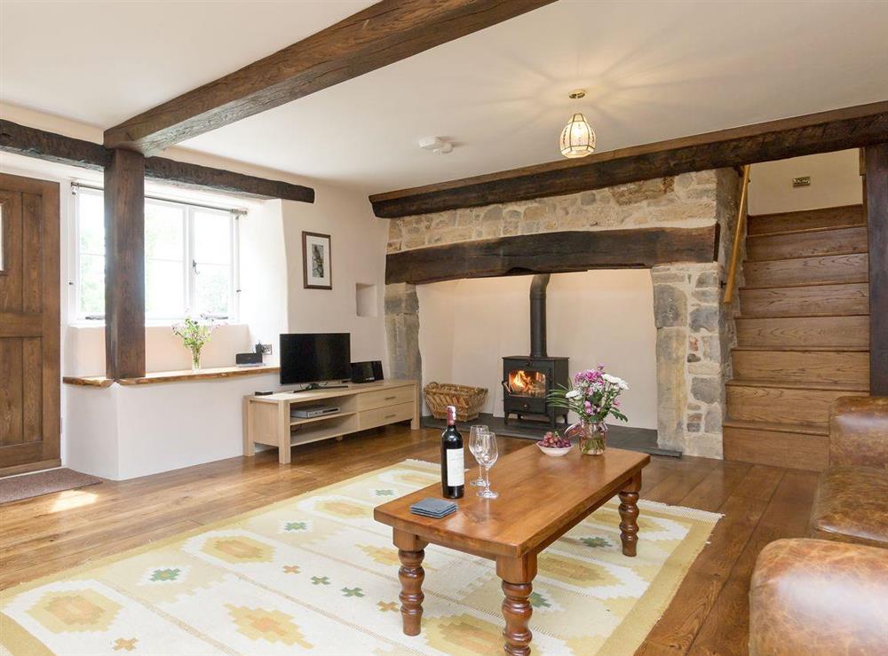 Spacious, beamed living room with inglenook fireplace at The Farmhouse at Higher Westwater Farm in Axminster, Devon