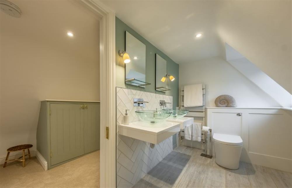 En-suite bathroom with bath, twin wash basins and WC at The Farmhouse, Nether Hall Estate, Pakenham