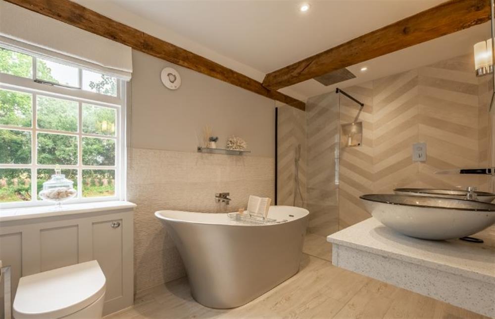 Large en-suite bathroom with feature slipper bath, walk-in shower and twin wash basins at The Farmhouse, Nether Hall Estate, Pakenham