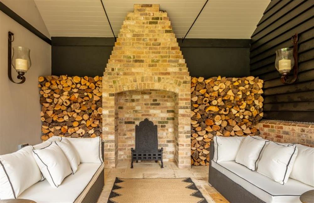 Undercover seating with an open fire at The Farmhouse, Nether Hall Estate, Pakenham