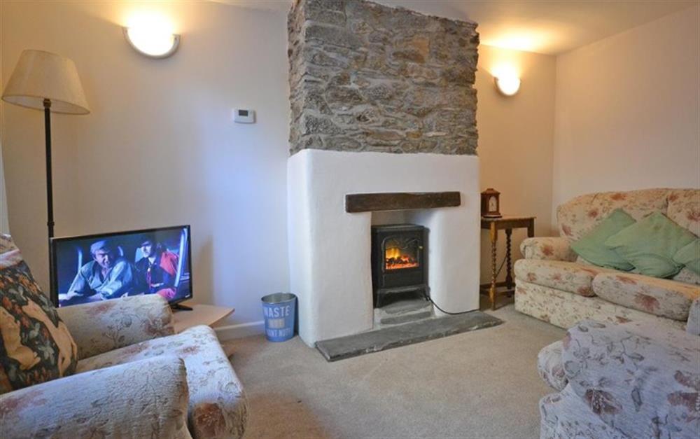 The sitting room with electric wood stove at The Fellery in Looe