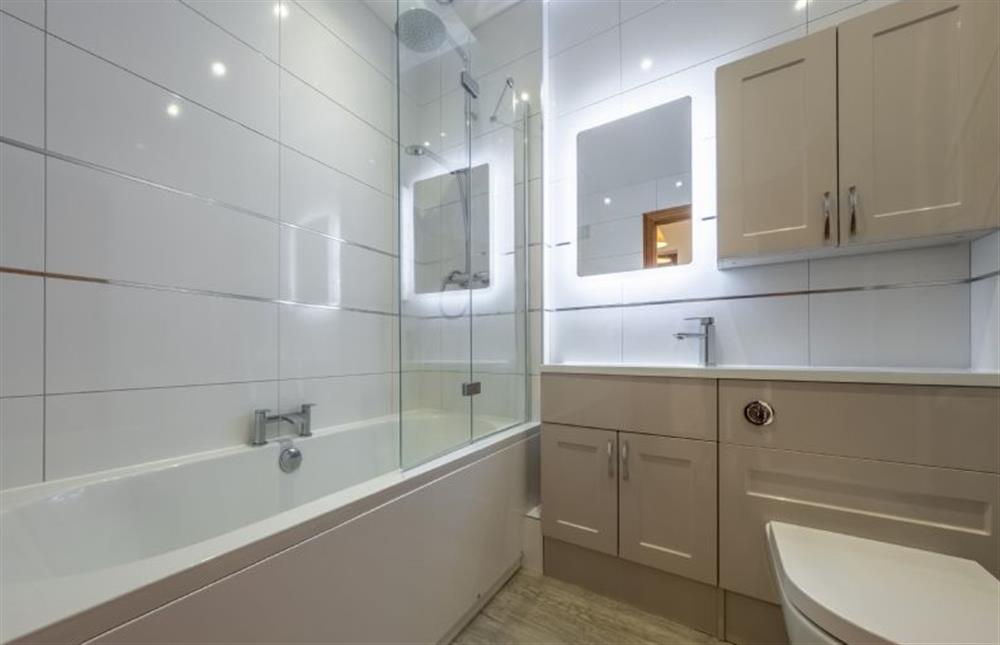 Bathroom with a bath with a shower over, WC and wash basin at The Felmingham, Roughton near Norwich