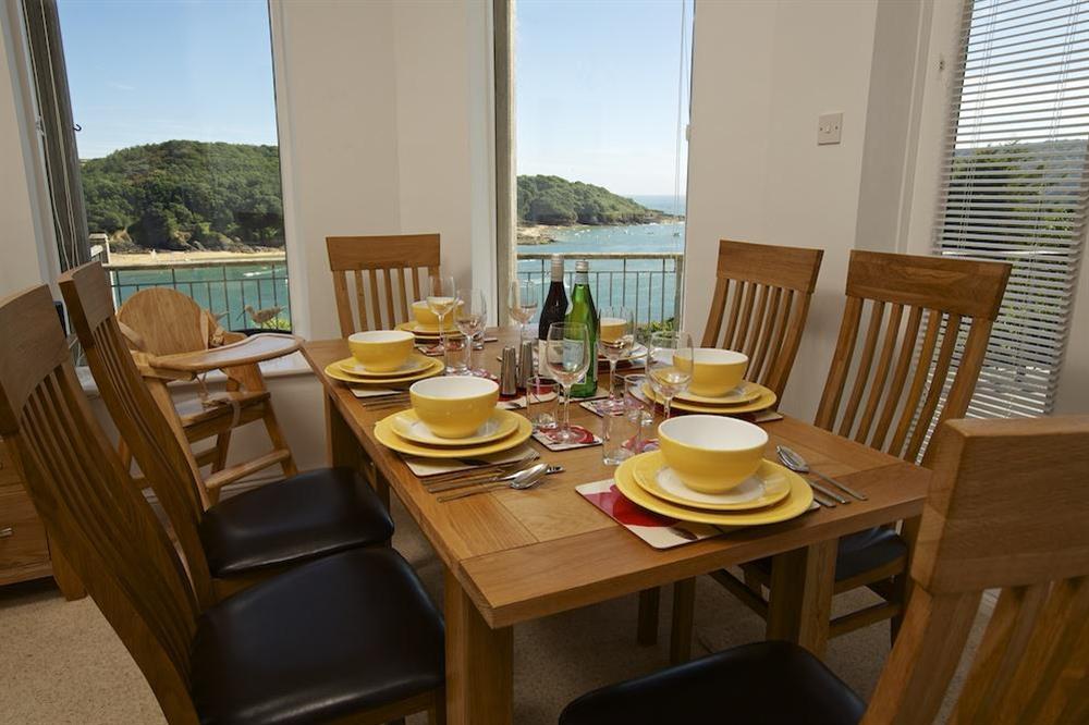 Dining area affords lovely estuary views and has a large oak table at The Garden House (Woodside) in , Salcombe